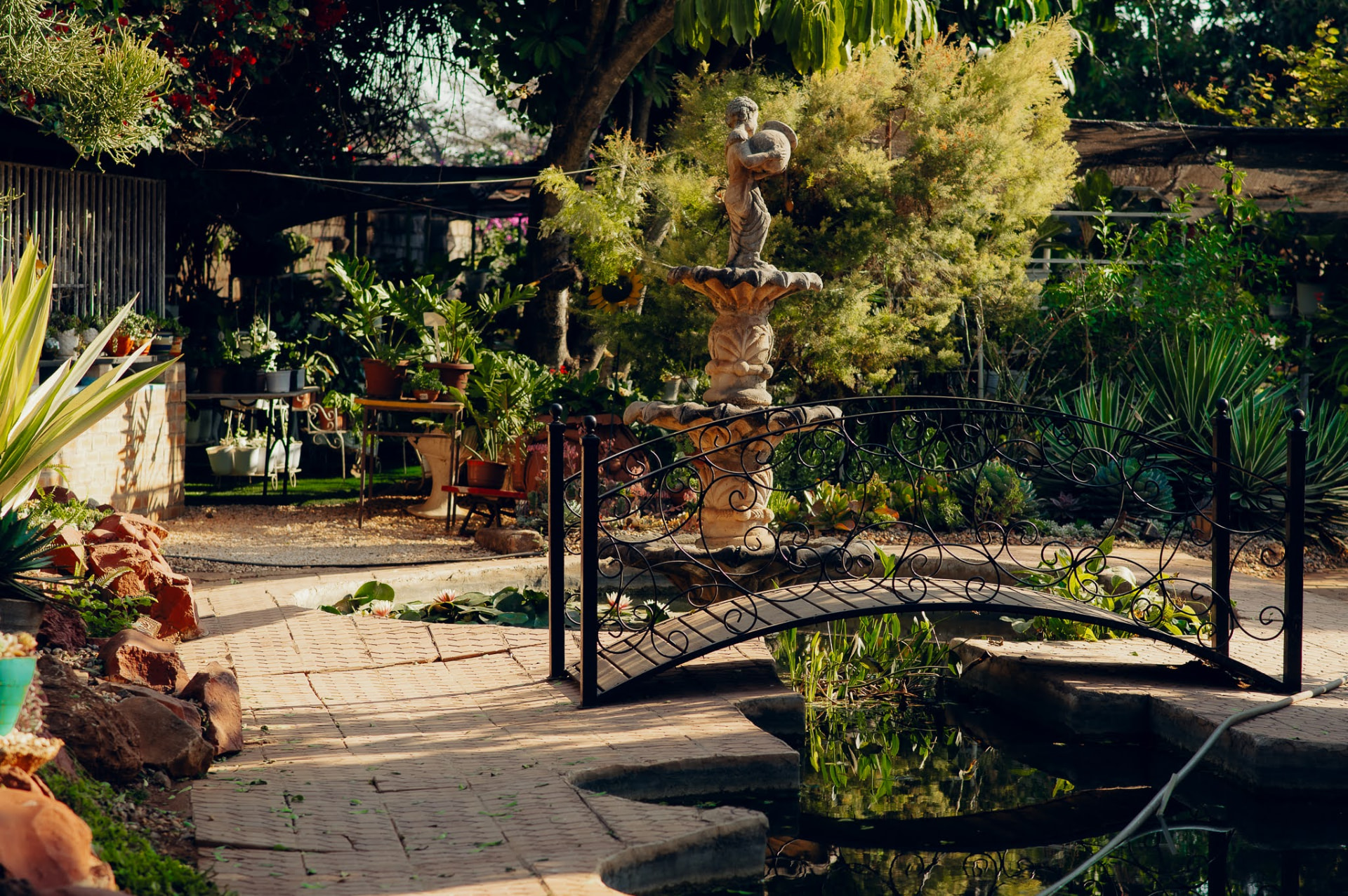 Ornamental fountain and wrought-iron bridge over the garden pond